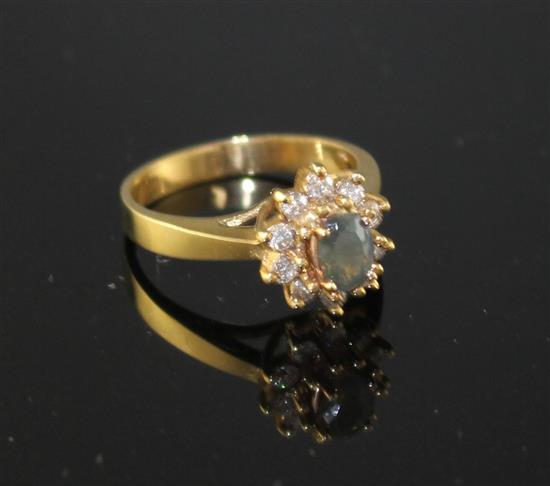 A modern 18k yellow metal, chrysoberyl? and diamond set oval cluster ring, size M, gross weight 4.2 grams.